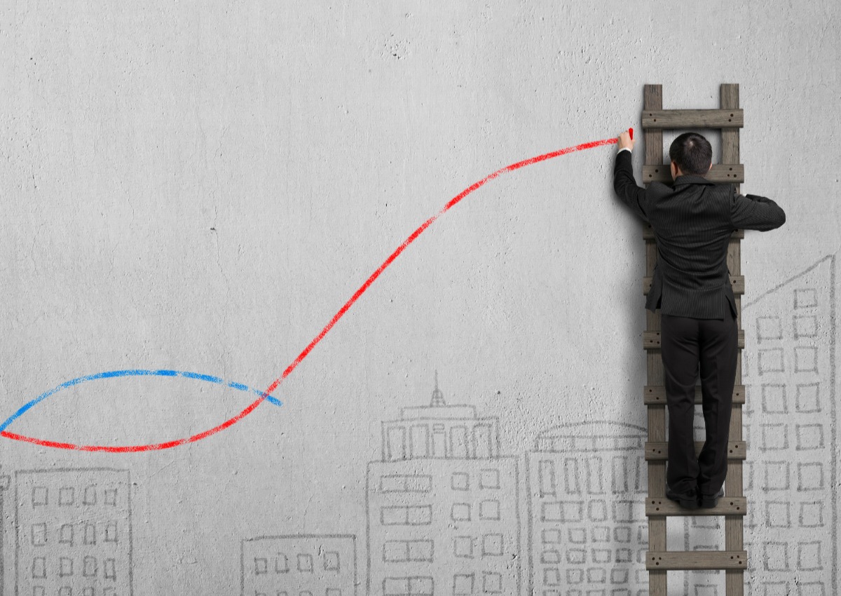 Man on a ladder drawing on a wall
