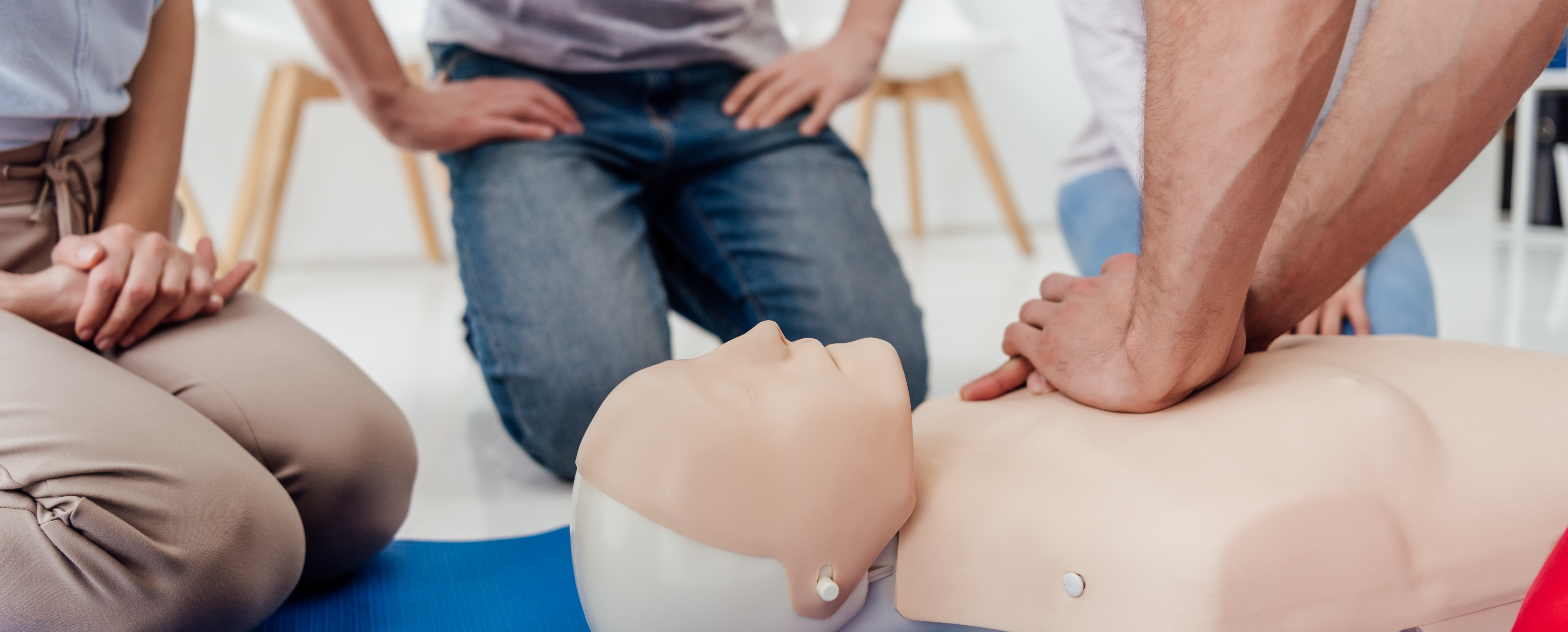 Instructor demonstrating CPR on a dummy
