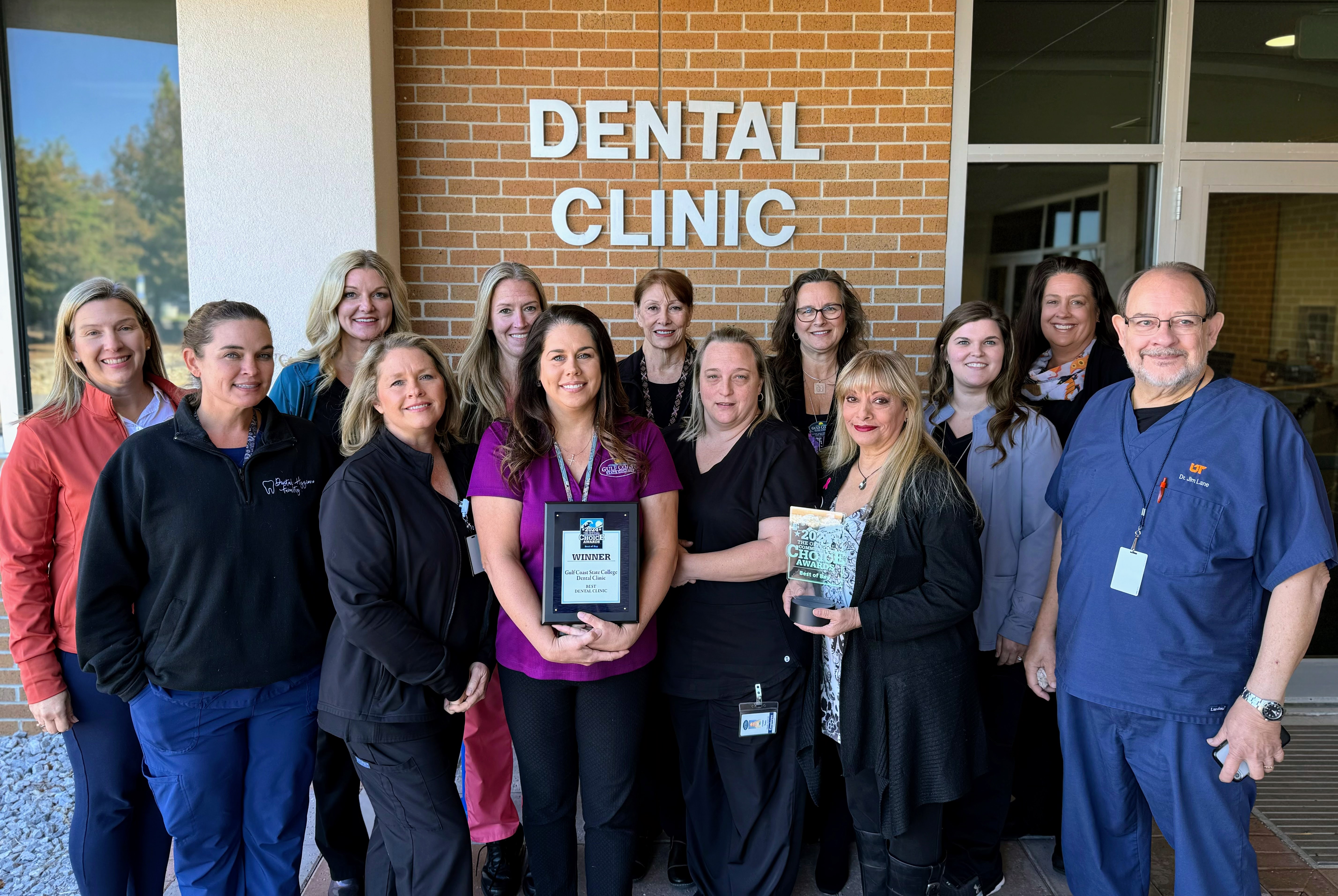 Group photo of dental clinic staff with "Best of Bay" award